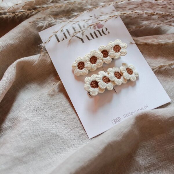 Set van twee witte geborduurde bloemen alligatorspeldjes met bruin hartje, gepresenteerd op een Little Yune kaartje.