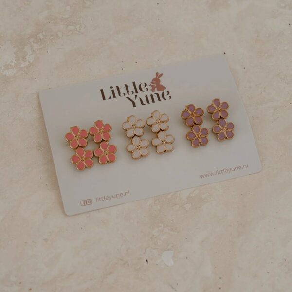 Set van drie paar haarspeldjes met bloemetjes in roze, wit en paars met een gouden randje, liggend op een Little Yune-kaartje.