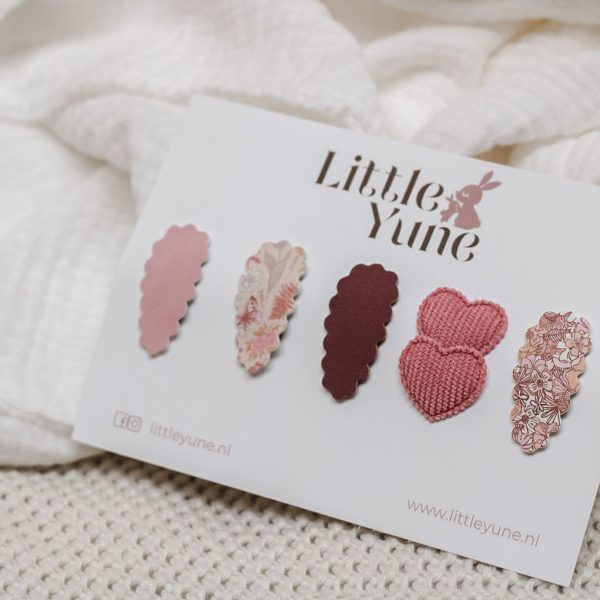 “Little Yune antislip haarspeldjes set ‘Rosie’ met vijf rozetinten: blush scallop, floral crème, berry scallop, duo knit-hartjes en floral scallop, gepresenteerd op witte Little Yune kaart.”