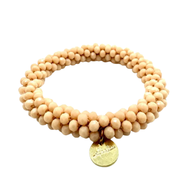 Beige haarelastiek en armband in één van Stiekie, gemaakt van kleine glanzende kraaltjes met een goudkleurig bedeltje – perfect voor in het haar én om je pols ✨