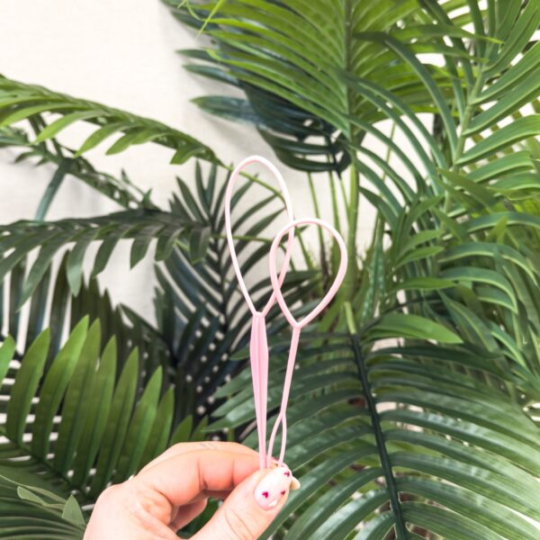 Roze haarlus tool (hair loop) om elastiekjes en plukjes haar makkelijk door te halen bij meisjeskapsels.