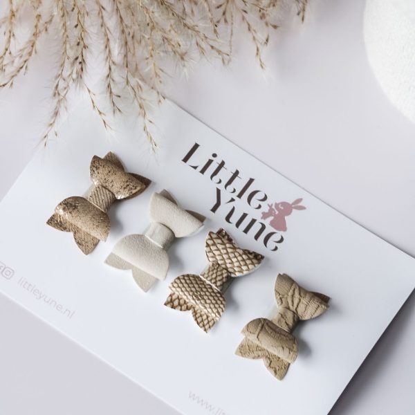 Vier antislip haarspeldjes in verschillende nude tinten en structuren, gepresenteerd op een Little Yune kaart met zachte droogbloemen op de achtergrond.