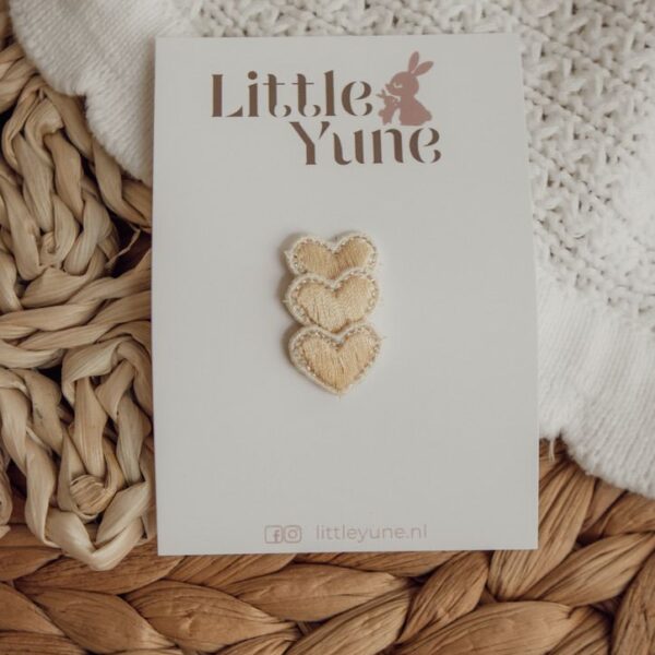 Crème met zachtgele geborduurde hartjes haarspeldjes in antislip uitvoering van Little Yune, bevestigd op een kaartje met konijntje-logo.