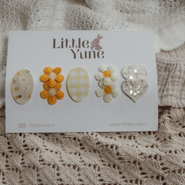 Antislip setje Soline van Little Yune met 5 speldjes in zachte geel-witte tinten, met bloemetjes, bijenprint, ruitjesprint en een glitter hartje.