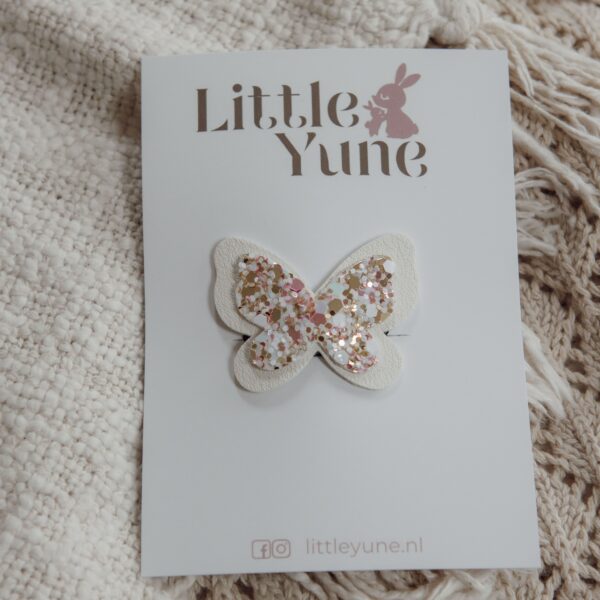 Wit antislip haarspeldje voor baby’s en meisjes met een vlindertje van wit imitatieleer en een glinsterend middenstuk in zachte roze-, goud- en crèmetinten.