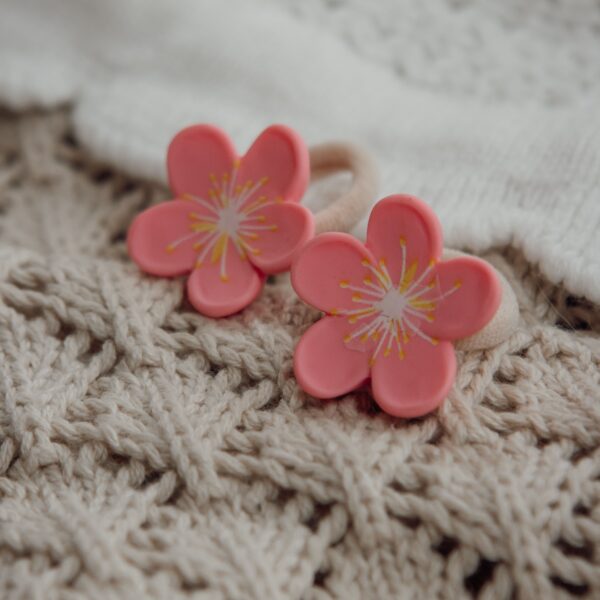 Elastiekjes Coral Blossom van Little Yune met twee zachte beige haarelastiekjes en koraalroze bloemetjes voor meisjes.