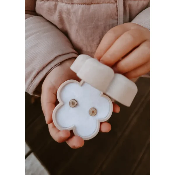 Mini sieradendoosje in de vorm van een madeliefje in zachte neutrale tint, met goudkleurige logo-afwerking, geschikt om oorbellen, ringetjes of kleine sieraden in cadeau te geven.
